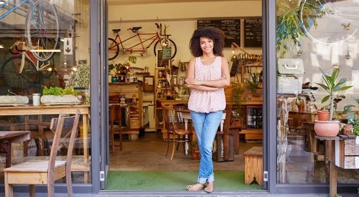 A business owner standing in the open doorway of her shop